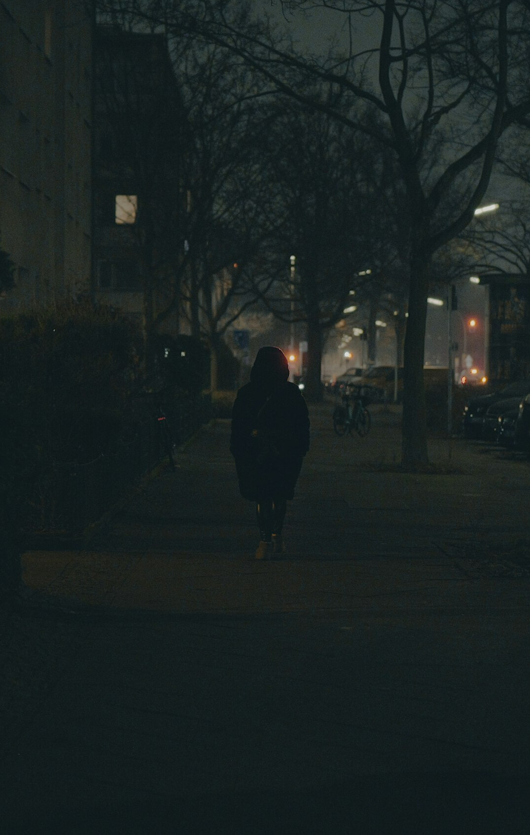 Anonymous silhouette of a person walking alone down a quiet street
